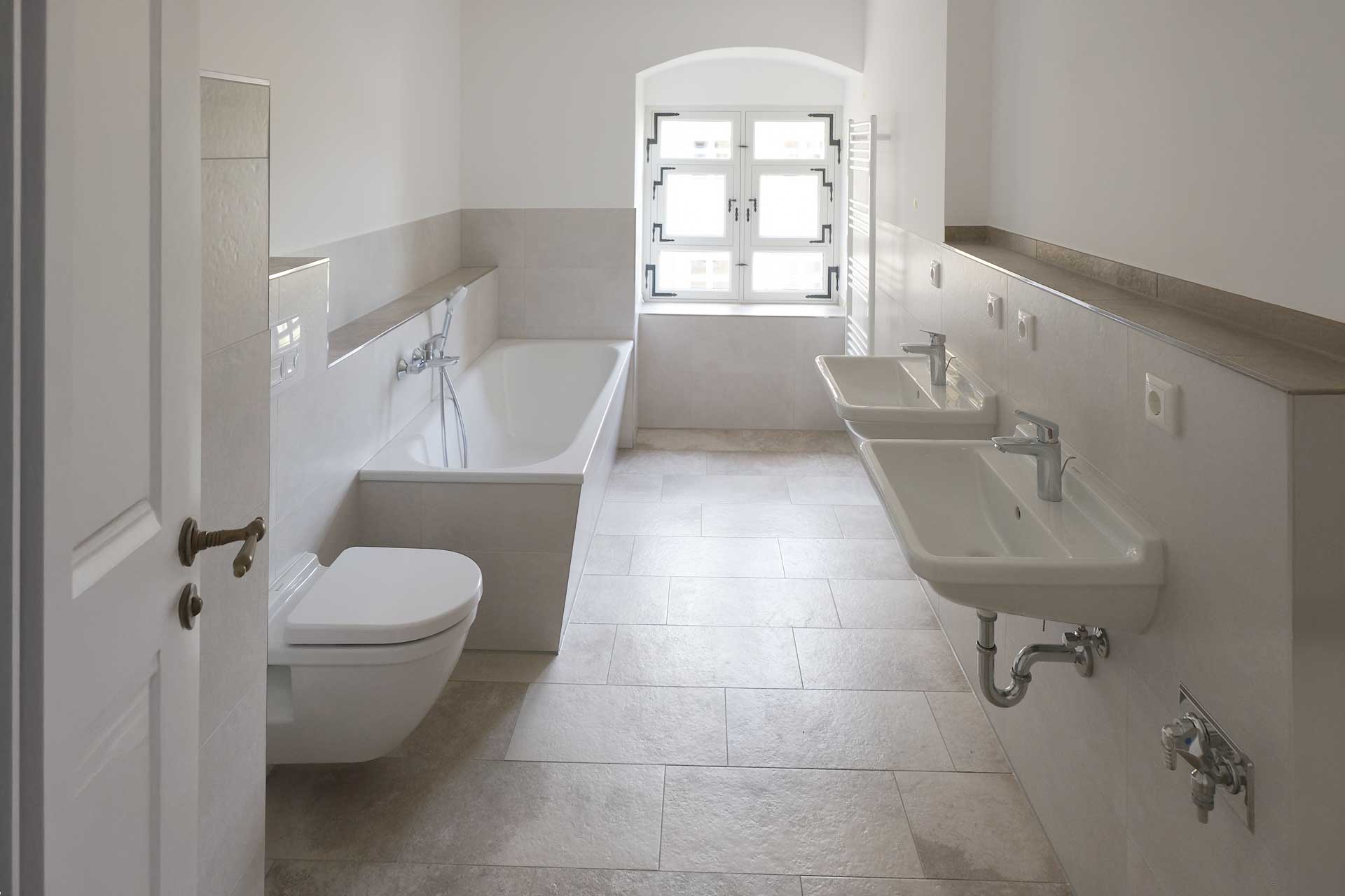 Barockschlosses Wachau Blick in Badezimmer mit Fenster, links 2 Waschbecken, rechts Toilette und Wanne